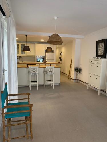 克里斯托港Casa Portoblau的厨房配有白色橱柜和桌椅