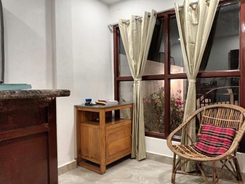 古瓦哈提GOVARDHAN HOME STAY ( Munna )的一间带椅子和桌子的房间以及窗户