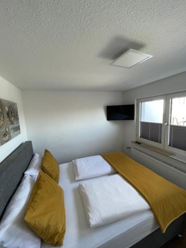 维尔茨堡Altstadt Hotel Self Check-In的卧室配有一张带黄色枕头的大型白色床。