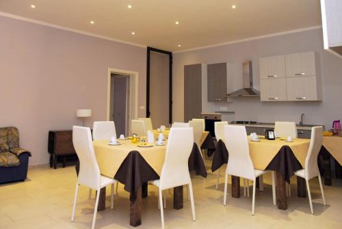 奥尼萨诺Pozzillo San Rocco的用餐室配有黄色桌子和白色椅子