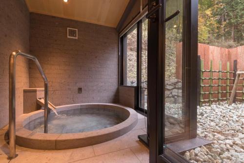 日光Nikko Nishimachi Club的带窗户的客房内的热水浴池