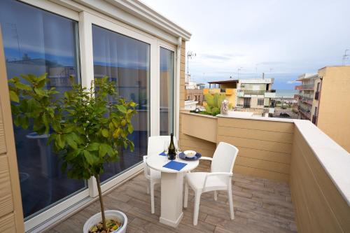 玛格丽塔萨沃亚Sopravento Apartments - Margherita di Savoia的阳台配有桌椅。