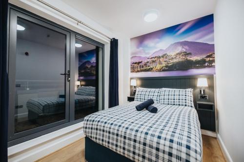 戈尔韦Snoozles Galway City Centre的一间卧室配有一张带 ⁇ 子毯子和窗户的床