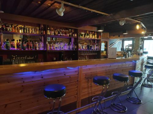 霍萨诺维德 - 霍桑洛马库斯度假村的木柜台前方的酒吧,设有蓝色凳子