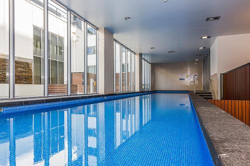 堪培拉堪培拉雷克斯酒店的一座大型游泳池,位于一座带窗户的建筑内