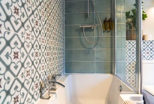 波特里Harbour House的浴室设有浴缸和蓝色瓷砖淋浴。