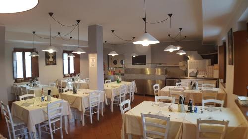 RoccafrancaOstello Molino Di Basso的用餐室配有白色的桌子和白色的椅子
