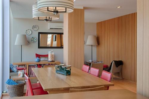 科英布拉奥斯陆酒店的一间带桌子和粉红色椅子的用餐室