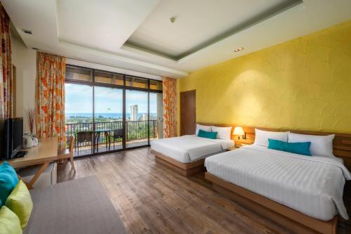 卡伦海滩卡隆普纳卡度假酒店的酒店客房设有两张床和大窗户。