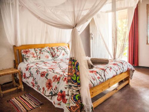 Cape Maclear图姆比景观山林小屋的一间卧室配有一张带天蓬的床