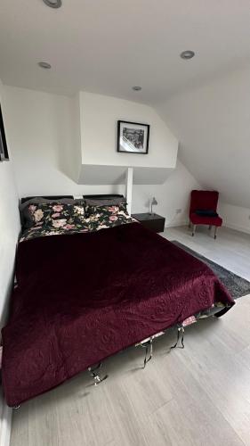 伦敦Stunning new 1 bedroom apartment的一间卧室配有一张大床和一张红色椅子