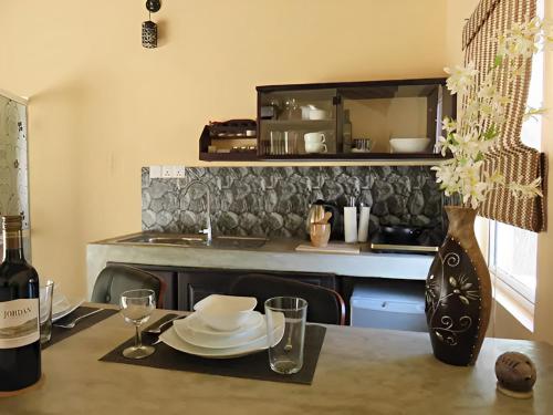 KottanitivuNayan's Paradise的厨房配有带盘子的桌子和一瓶葡萄酒