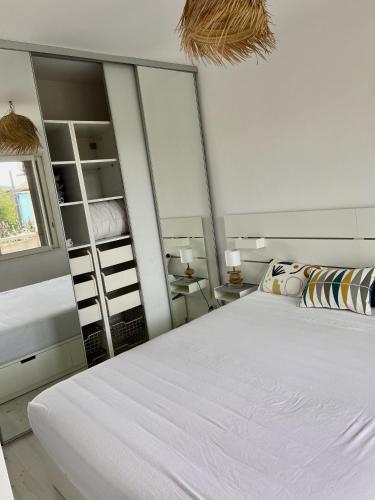 滨海圣西尔La Frégate - appartement à 100 m de la plage的卧室配有一张白色大床和镜子