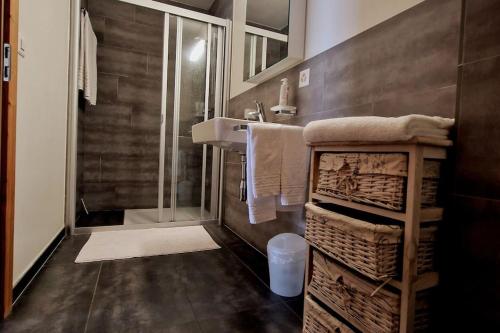 尚佩克斯Superbe appartement Champex-Lac avec piscine et sauna的带淋浴、水槽和毛巾的浴室