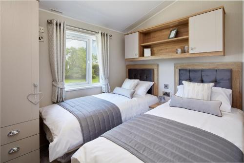 Burgh le MarshSycamore Farm Park的卧室设有两张床,带窗户