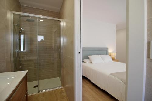洛萨尔德拉韦拉Casa Verata的一间卧室设有淋浴、一张床和一个水槽。