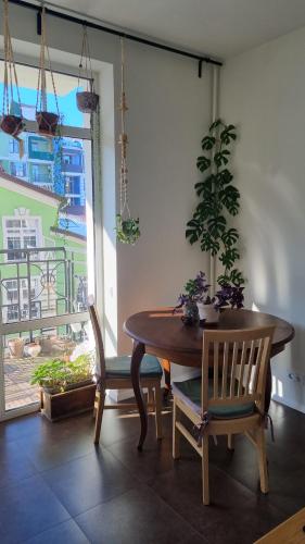 基辅Kyiv Jungle apartment的一间带桌椅和窗户的用餐室