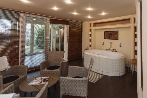 佩奇Hilltop Wellness Villa-big garden, sauna, hot tube的带浴缸和桌椅的浴室