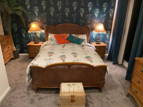 圣奥斯特尔Palm View Luxury Botanical Themed apartment with sauna的一间卧室配有一张带2个床头柜和2盏灯的床。
