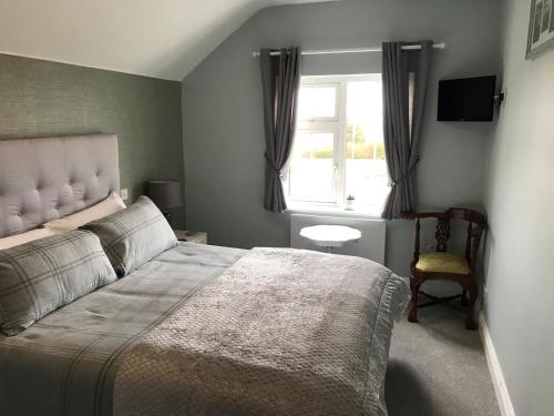 瓦特维尔Kielty's of Kerry Bed and Breakfast的一间卧室设有一张大床和一个窗户。