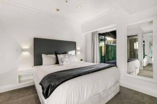 奥克兰THE VIADUCT WATERFRONT LUXURY - Views & Location!的白色的卧室设有一张大床和一个窗户