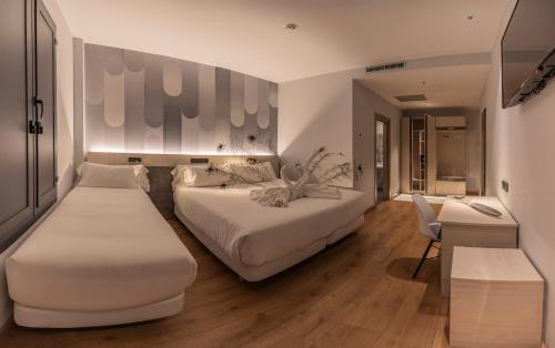 莱昂Hotel NERU con Encanto的酒店客房,设有两张床和一张沙发