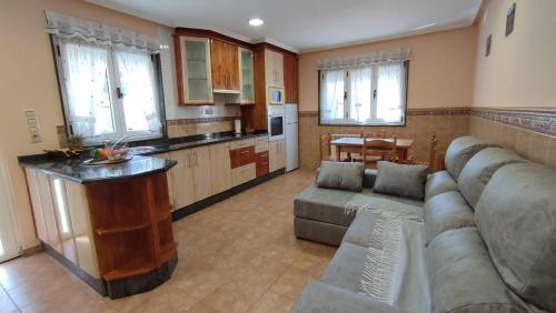 CortinaApartamentos Casa Alvarina - Luarca的带沙发的大客厅和厨房