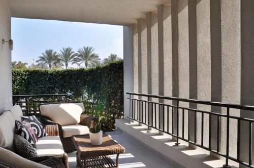 开罗Axxodia Cairo Festival Residence的阳台配有2把椅子和桌子
