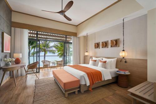 芽庄Boma Resort Nha Trang的一间卧室配有一张床、一张书桌和一个窗户。