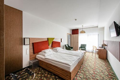 威利兹卡里纳特酒店的卧室配有一张床和一张桌子及椅子