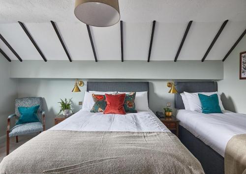 胡克The New Inn Heckfield的一间卧室配有一张带色彩缤纷枕头的大床