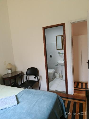 里约热内卢Estúdios Deluxe São Manuel的一间带一张床的卧室和一间带镜子的浴室