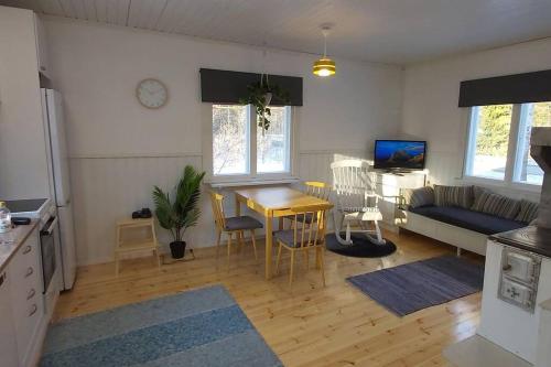 KontiolahtiVilla Mäntysaari luonnonrauhaa kaupungin lähellä.的厨房以及带桌子和沙发的客厅。