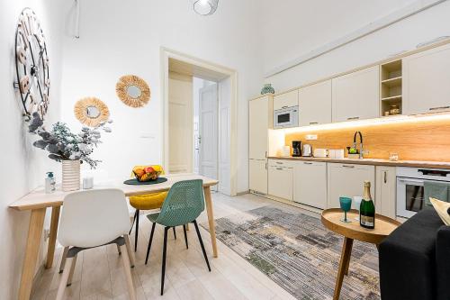 科希策Center Apartment Mlynska Kosice with private Parking的厨房以及带桌椅的起居室。