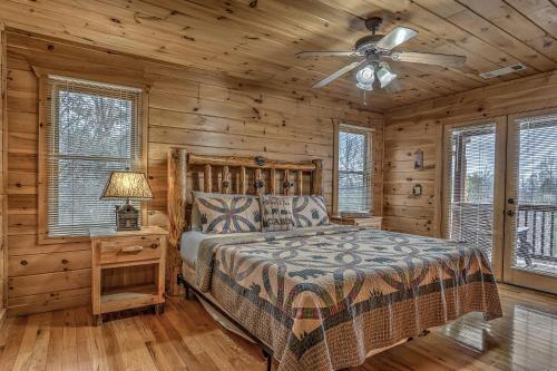 蓝岭Cozy Blue Ridge Cabin in Heart of the Mountains的一间卧室配有一张床和吊扇