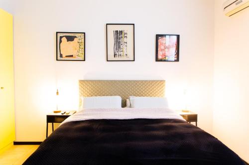 特拉维夫沙尔玛公寓的卧室配有一张床,墙上有三幅照片