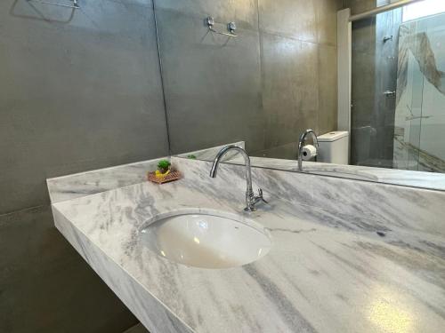 戈亚尼亚Apartamento aconchegante 1911的浴室的柜台设有水槽和镜子