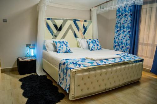 纳库鲁The Fancy Luxurious 3 bedroom apartment的一间卧室配有一张带蓝色和白色枕头的床