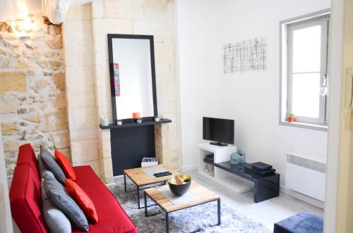 波尔多阿基坦大区伊斯盖尔酒店的客厅配有红色沙发和电视