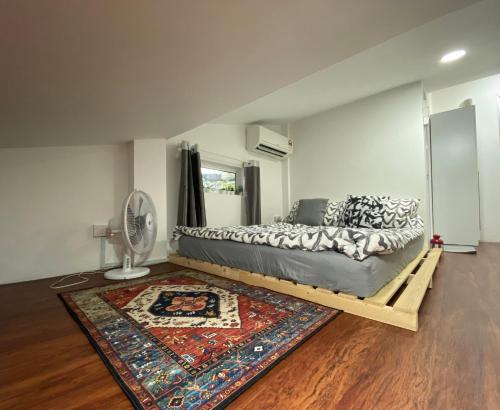 新山Sweet Loft Homestay的一间卧室配有一张带地毯的床和风扇