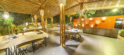 萨三吉尔Amraness Luxury Resort Sasan Gir的大楼内带桌椅的餐厅
