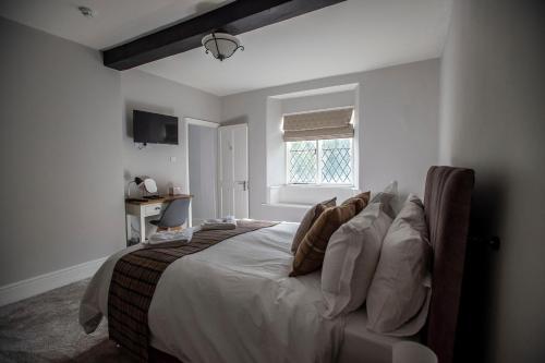 科文The Berwyn Arms的一间卧室配有带白色床单和枕头的床。