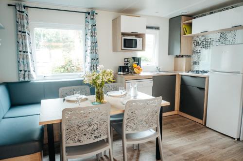 AllardsMobil Home XXL 4 chambres - Camping Ostrea的厨房以及带桌椅的用餐室。