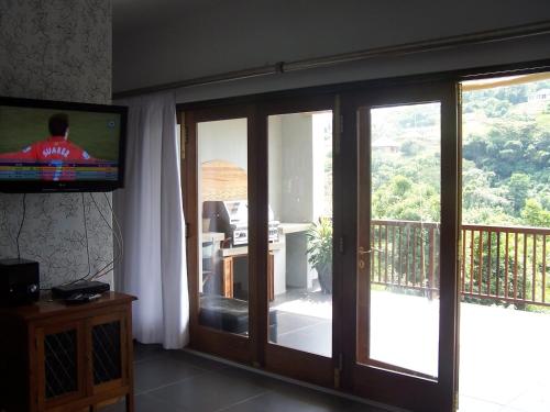 克卢夫Nkutu River Lodge的客厅设有滑动玻璃门和电视