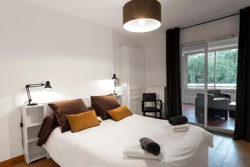卡尔卡松艾乐欧公寓酒店的卧室配有带棕色枕头的大型白色床
