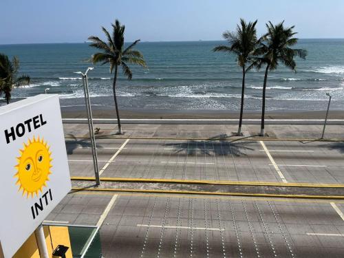 博卡德尔里奥HOTEL INTI的棕榈树海滩前的酒店标志