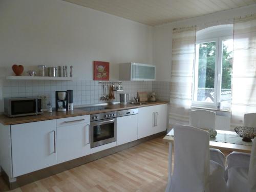 博特罗普Glück im Kohlenpott的一间厨房,配有白色家电和桌椅