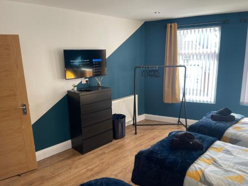 利物浦Anfield accomodation的一间卧室配有两张床和一台平面电视