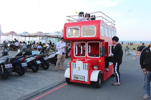 基隆Sea Keelung的一辆红色双层巴士停在摩托车旁边