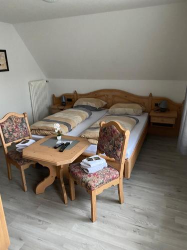 德罗尔斯哈根Buddes Wirtshaus的一间卧室配有两张床和一张桌子及椅子